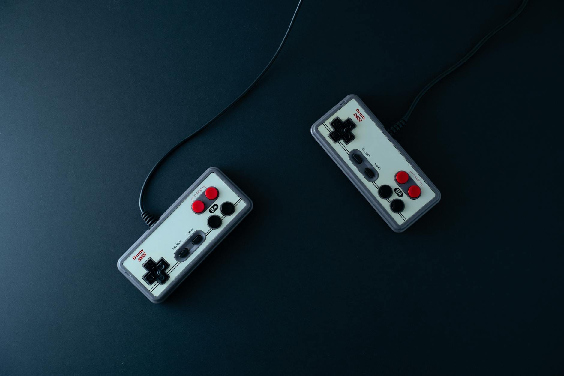 Dwa retro pady do gier na ciemnym, minimalistycznym tle