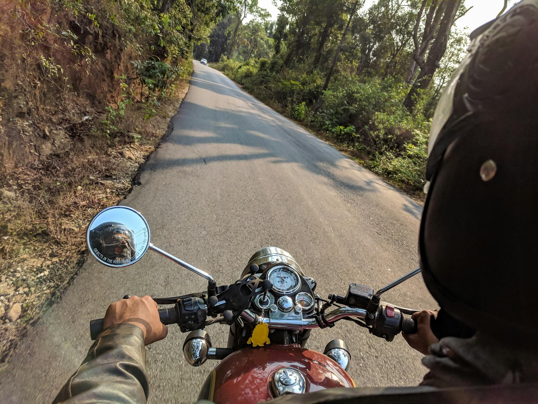 Motocyklista jedzie drogą przez las w czasie dalszej trasy