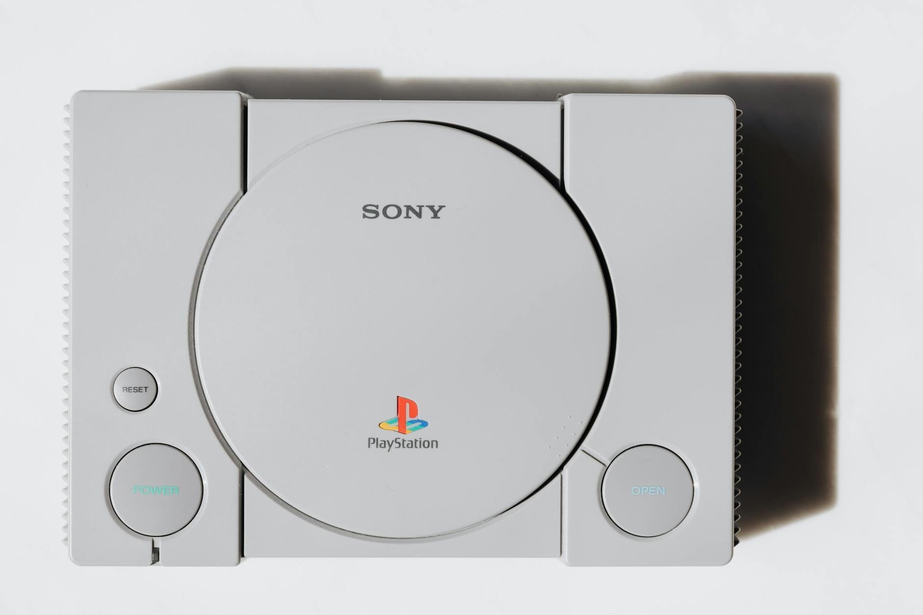 Zbliżenie na klasyczną konsolę Sony PlayStation na białym tle