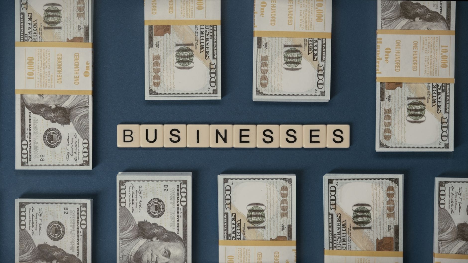 Plikujące banknoty dolarowe obok liter układających się w słowo businesses