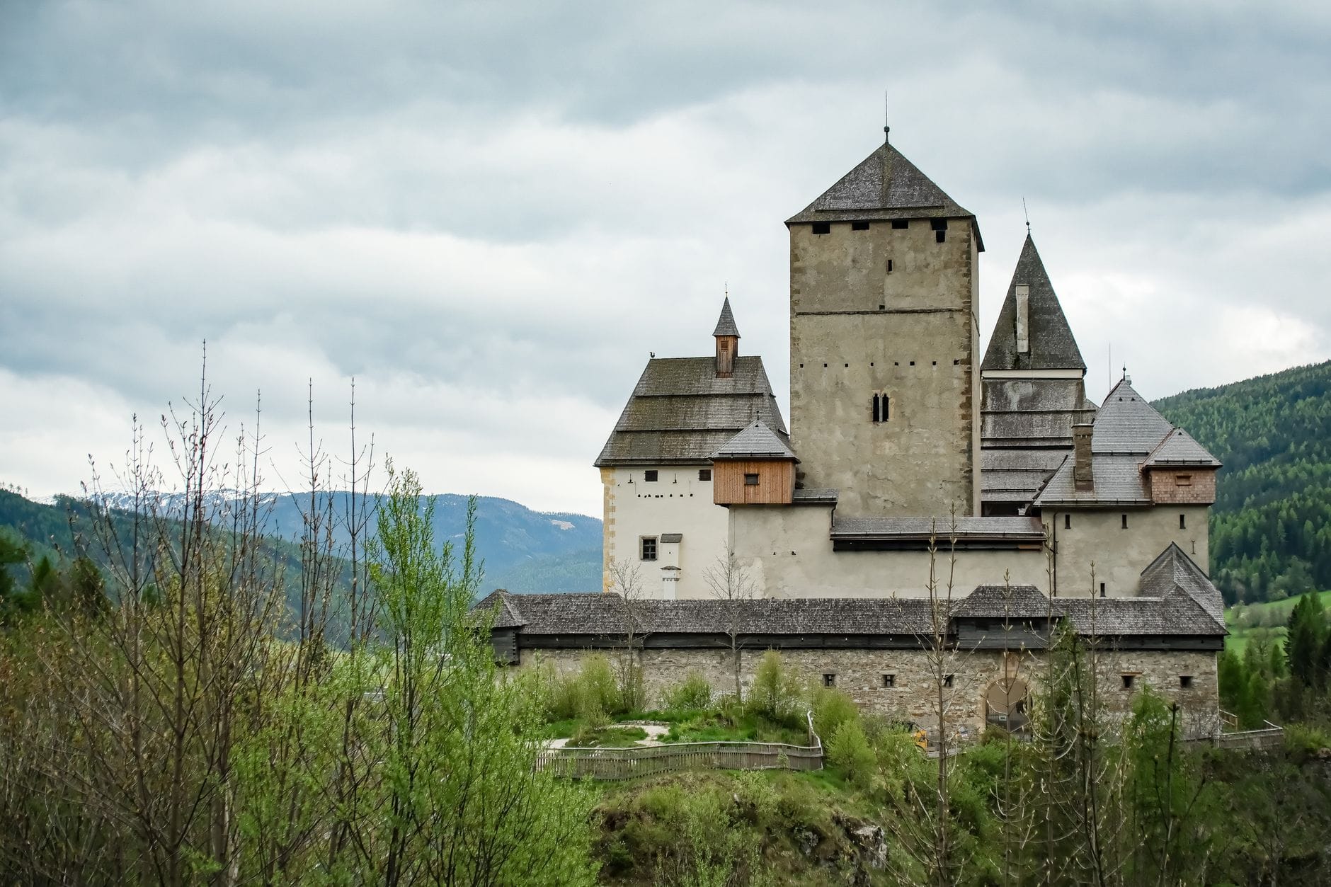 Zamek Mauterndorf otoczony zielenią w górskim krajobrazie