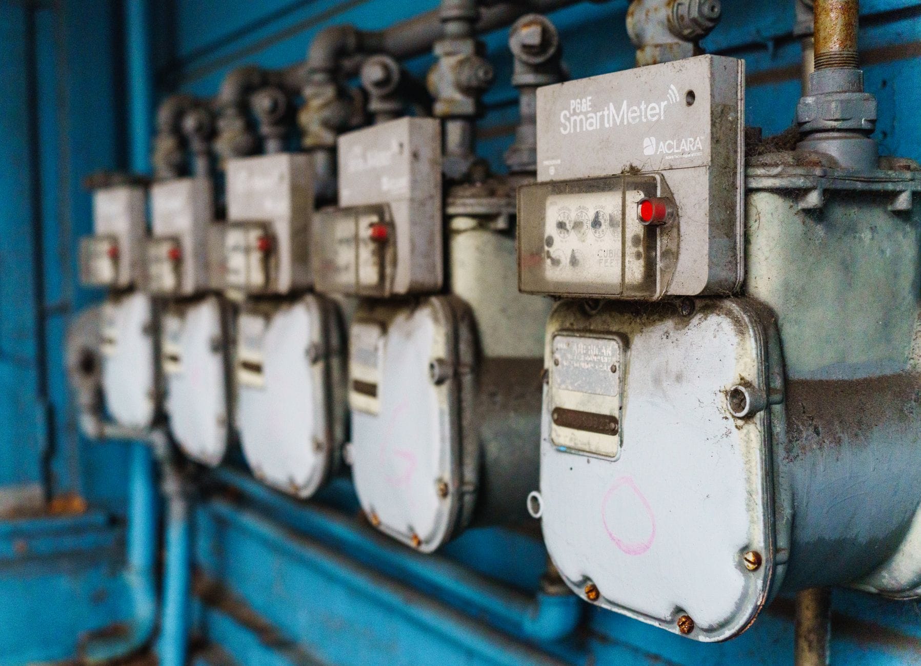 Rząd inteligentnych liczników energii na niebieskiej ścianie przemysłowej