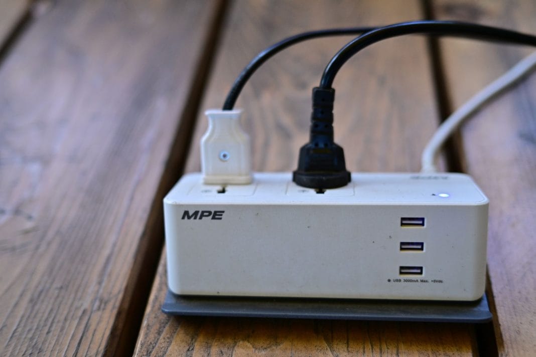 Listwa zasilająca z portami USB i podłączonymi kablami na biurku Listwa zasilająca z portami USB i podłączonymi kablami na biurku