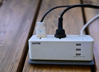 Bezpieczeństwo pracowników: instrukcja użytkowania firmowych ładowarek Listwa zasilająca z portami USB i podłączonymi kablami na biurku