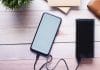 Smartfon ładowany powerbankiem na drewnianym biurku